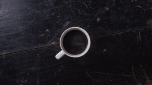 Looping cinemagraph of fresh hot coffee in a cup on a wooden table.